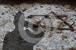 Shadow of an Israeli soldier saluting a gravestone with a Jewish star from tree branches. Yom Hazikaron