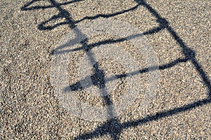 Shadow of a ladder casted on pebbles