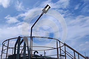 THE SHADOW OF A LAMP AT NOON, UNDER A BLUE SKY