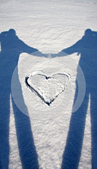 Shadow of lovers with heart on snow