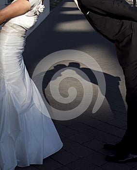 Shadow of newlywed couple leaning forward, kissing