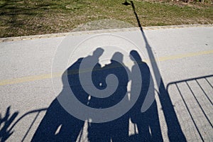 Shadow from people and street lamp in the park on a sunny day