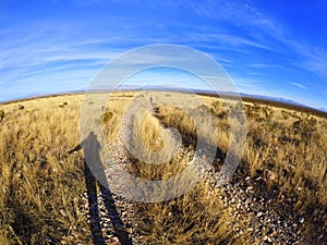 Shadow of Person in Afternoon Sun Along a Dirt Road in an Arizona Arid Desert Landscape