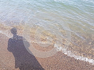 Shadow of a Person Casted on the Beach and Tide