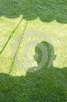 Shadow of person on a green field