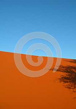 Shadow on red arid sand dunes