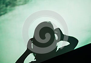 Shadow silhouette of female woman screaming scared holding head with hand