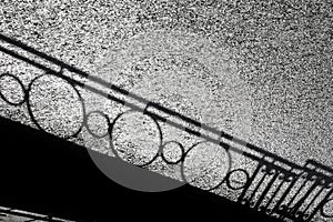 Shadow silhouette of a low wrought iron decorative vintage fence in the city park