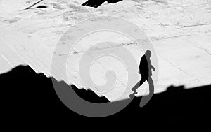 Shadow silhouette of a man walking alone down city stairs