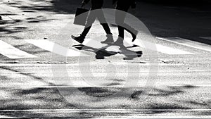 Shadow silhouette of pedestrians crossing city street