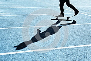 Shadow of a skateboarder on asphalt. Blue toning