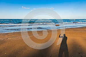 Shadow of a man on the sand by the sea