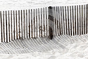 The shadow thrown by a fence on the beach