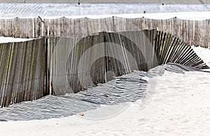 The shadow thrown by a fence on the beach