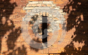 The shadow of the tree falls on the stone wall