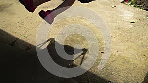 Shadow of unrecognizable boy child on a swing seat in summer afternoon.