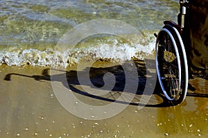 Shadow of a wheelchair in the sand on the seashore
