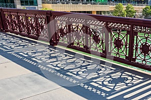 Shadows from fence design display on Wells St bridge in Chicago Loop