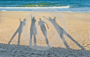 Shadows of four people against the background of the sea and sky