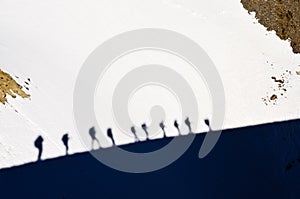 Shadows of group of mountain trekkers on a snow