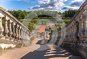 Shadows of old stairs to green garden under blue sky with bulky clouds in summer Petergof