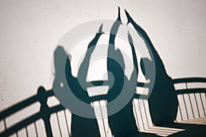 Shadows of people gesturing high five