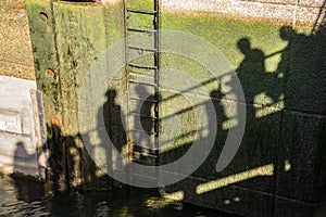 Shadows of people walking on bridge