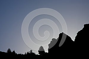 Shadows of rocks and trees just before sunrise on mountain slopes