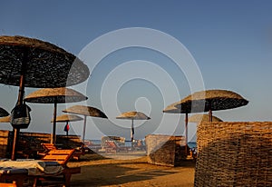 shadows and sun on the beach area with sun umbrellas and lounges on the sand with the red sea