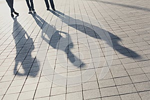 Shadows of three friends on pavement