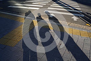 Shadows of three friends standing on the street in sunlight