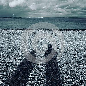 Shadows of two people on the beach