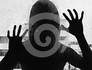 Shadowy figure with a knife behind glass