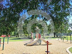 Shady from large trees and colorful urban playground at public park in downtown Dallas, Texas, USA