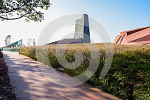 Shady path in bristlegrass and shrubs before modern building on