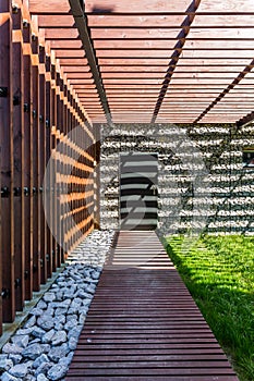 Shady wooden path to stone house