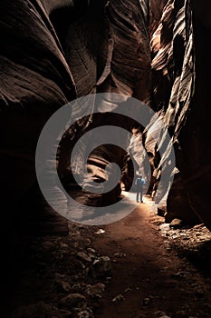 A Shaft of Sunlight Illuminates Hiker In Slot Canyon