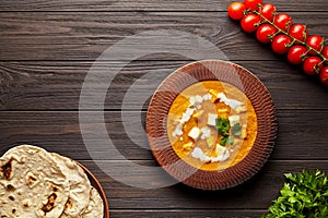 Shahi paneer traditional Indian vegetarian food with vegetables and butter paneer cheese on dark wooden background