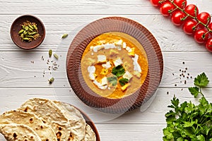 Shahi paneer traditional Indian vegetarian masala gravy meal vegetables, white sauce and butter paneer in clay bowl photo