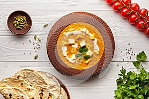 Shahi paneer traditional Indian vegetarian masala gravy meal vegetables, white sauce and butter paneer in clay bowl