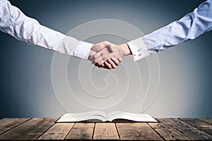 Shake hands on open books