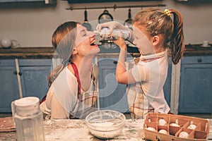 Shaked whipped cream. Happy loving family are preparing bakery together. Mother and child daughter girl are cooking photo