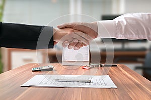 Shakehand of lawyer and business woman sitting behind desk with agreement photo