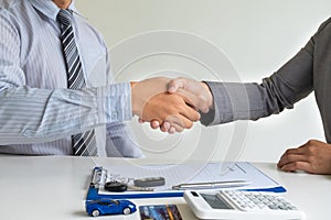 Shaking hands, Car dealership provides advice about insurance details and car rental information and delivers the keys