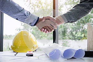 Shaking hands of collaboration, Construction engineering or architect discuss a blueprint while checking information on drawing