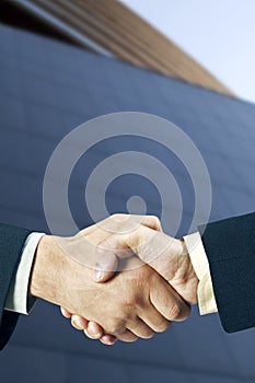 Shaking hands in front of a building