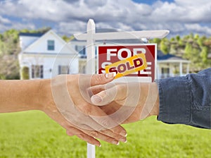 Shaking Hands in Front of New House and Sold Sign