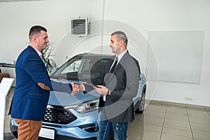 shaking hands with two man salesman and client after success deal selling or rental car