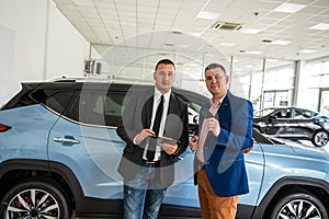 shaking hands with two man salesman and client after success deal selling or rental car