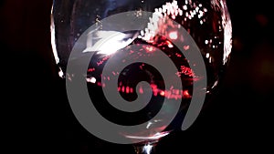 Shaking red wine glass by man hand. Stock footage. Close up of a sommelier is shaking wineglass with red wine in his